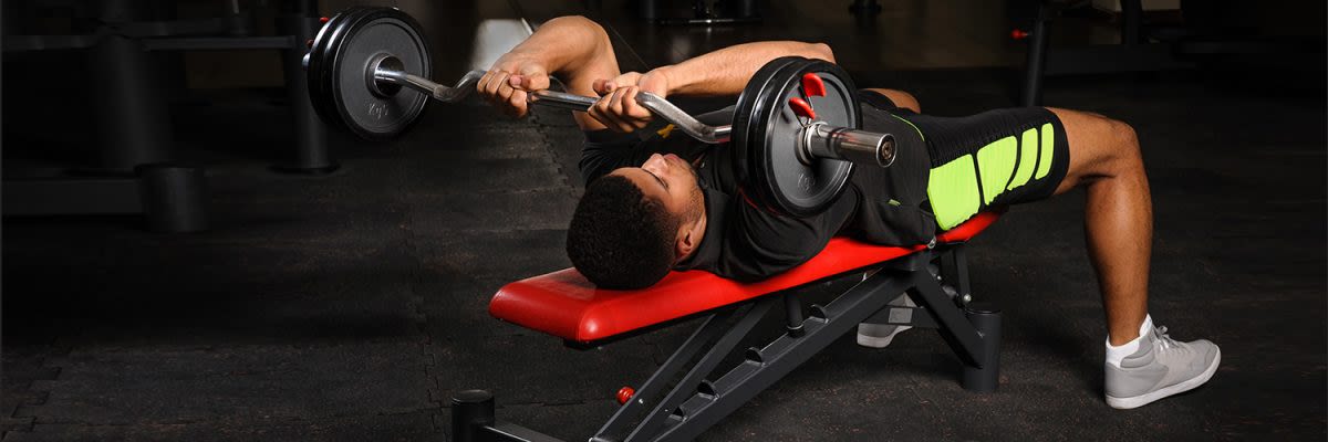 man liggend in skull crusher positie