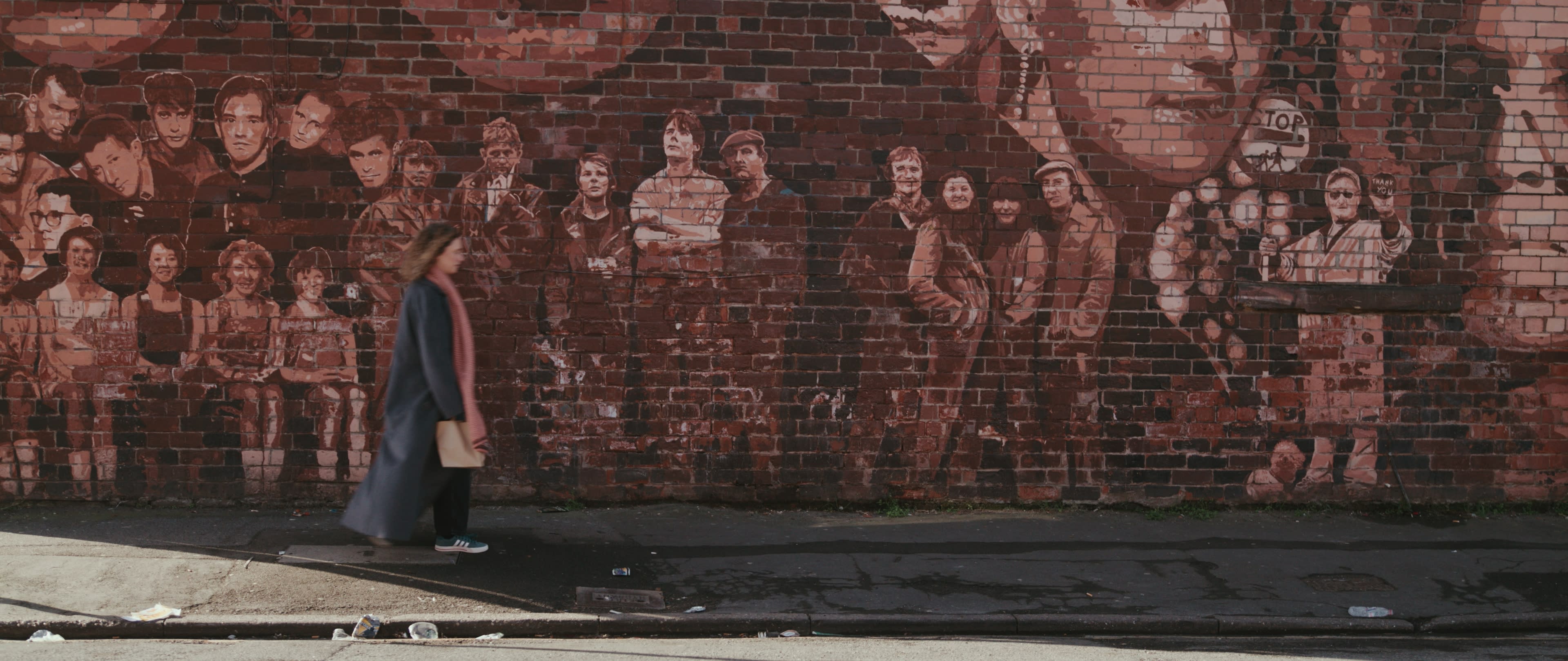 Hannah stands before a mural in Hull in a still from Inheritance