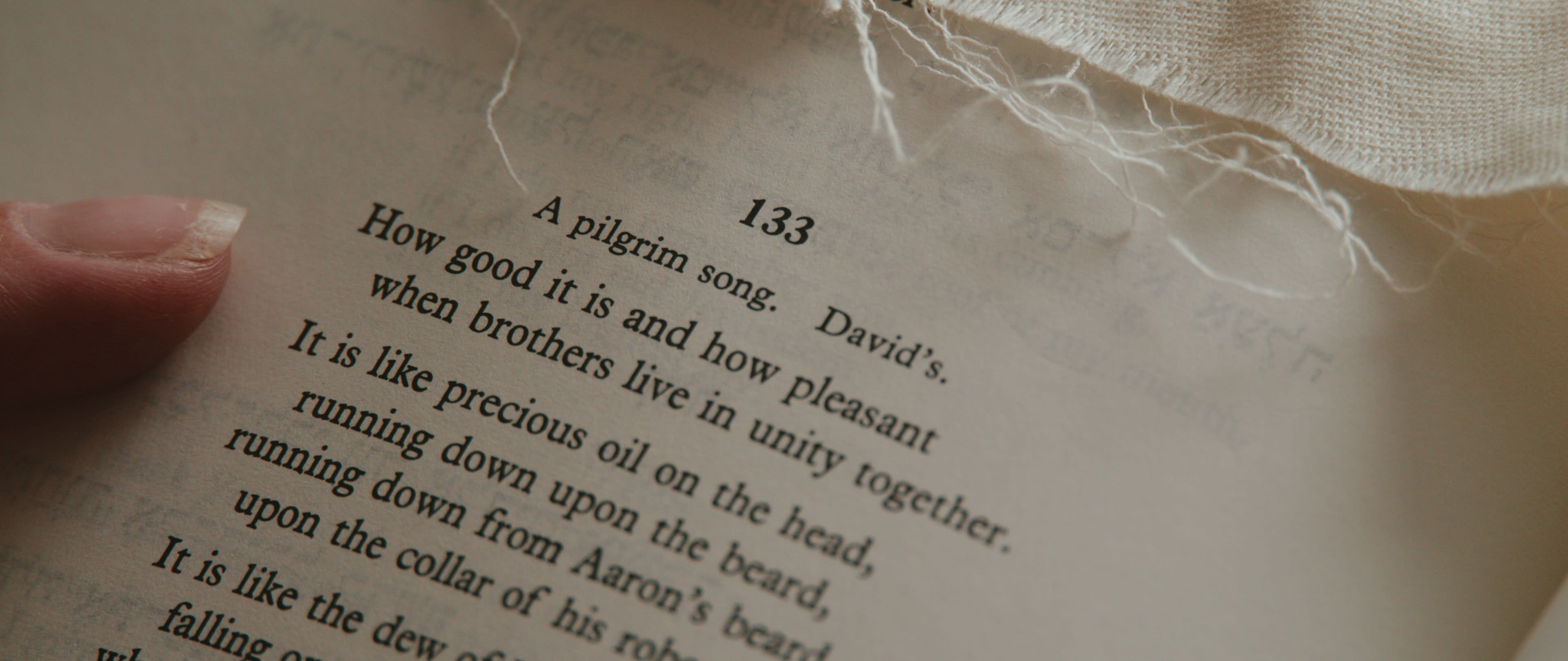 A hand rests on a page of Hebrew prayer text