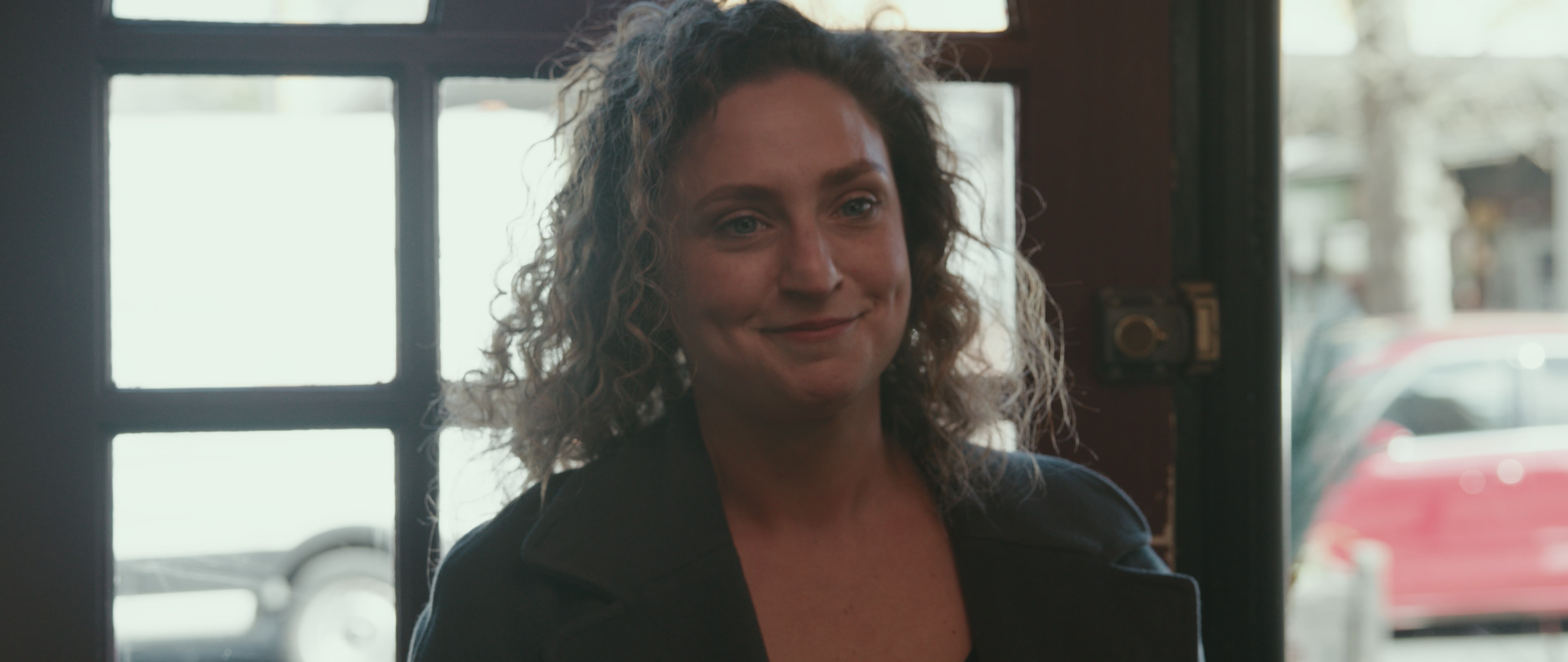 Hannah in a café in a still from Inheritance
