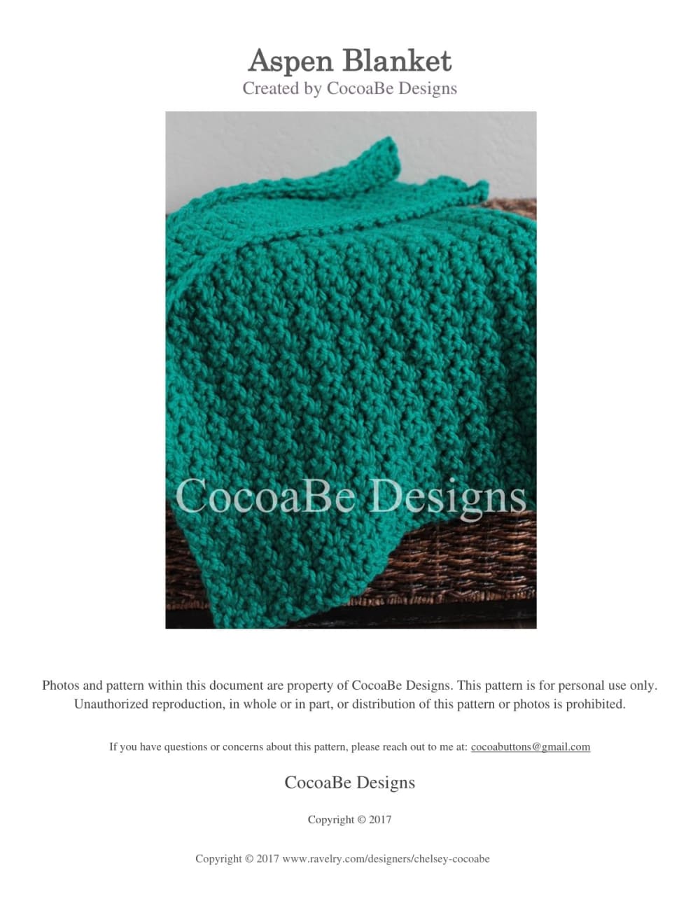 Thick emerald green chunky crochet Aspen baby blanket with a textured stitch and wavy edge on a wicker basket