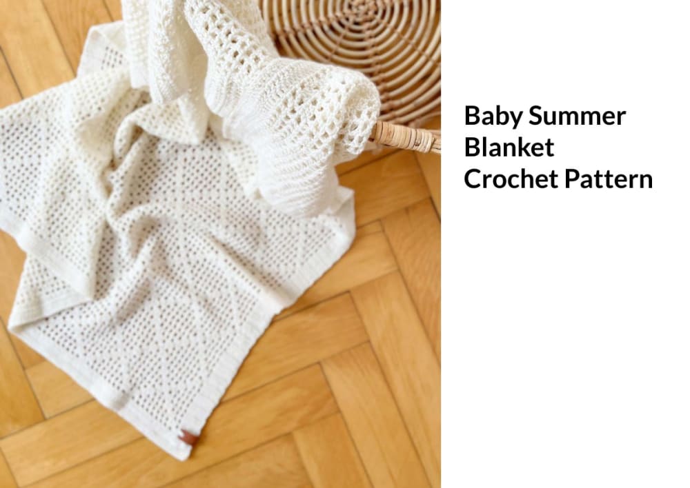 Cream filet crochet baby summer blanket lying on a wooden floor