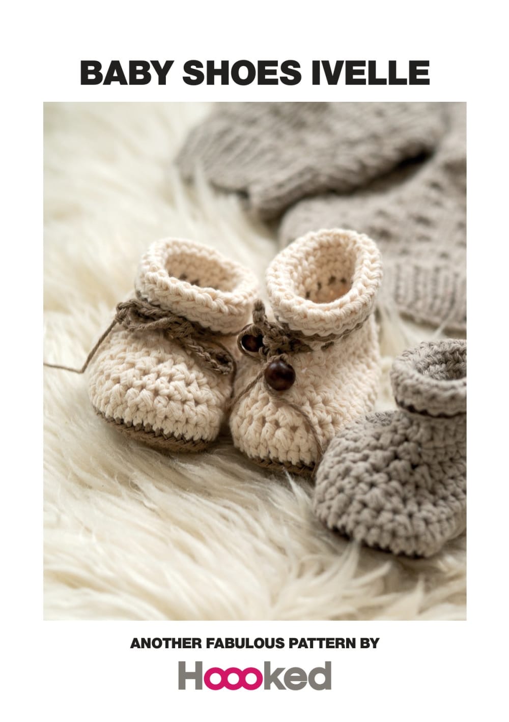 Cream crochet baby shoes with a folded cuff and a small button, placed on a white fur rug