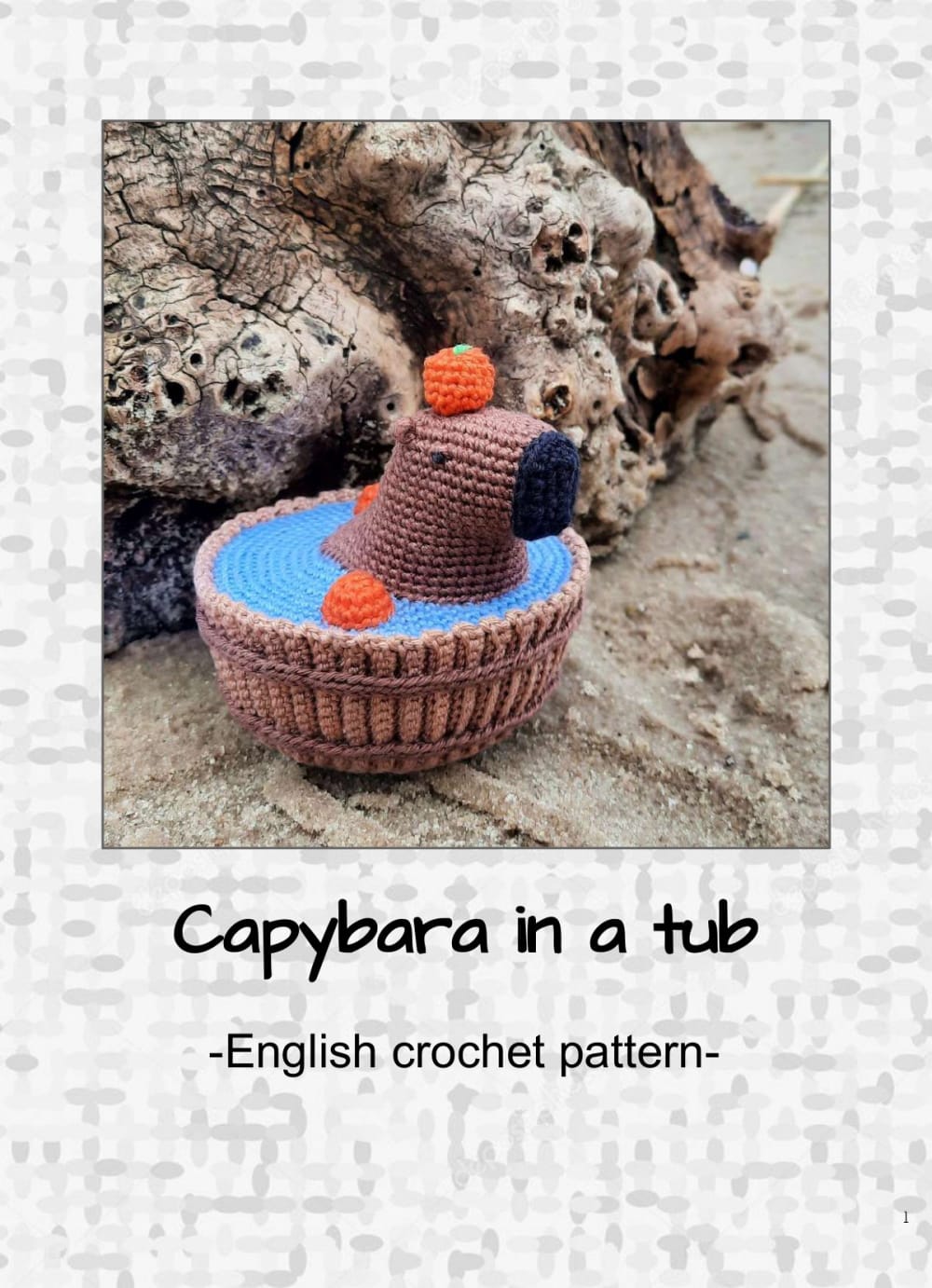 Tiny brown crochet capybara with an orange on its head sitting in a brown crochet tub with a blue water surface