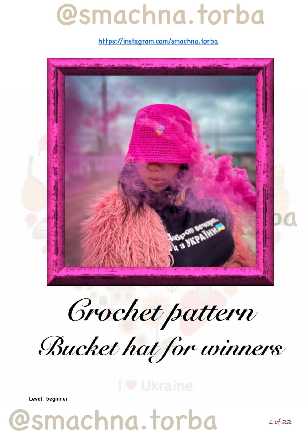 Bright pink crochet raffia bucket hat with a shiny finish and a small charm on the front