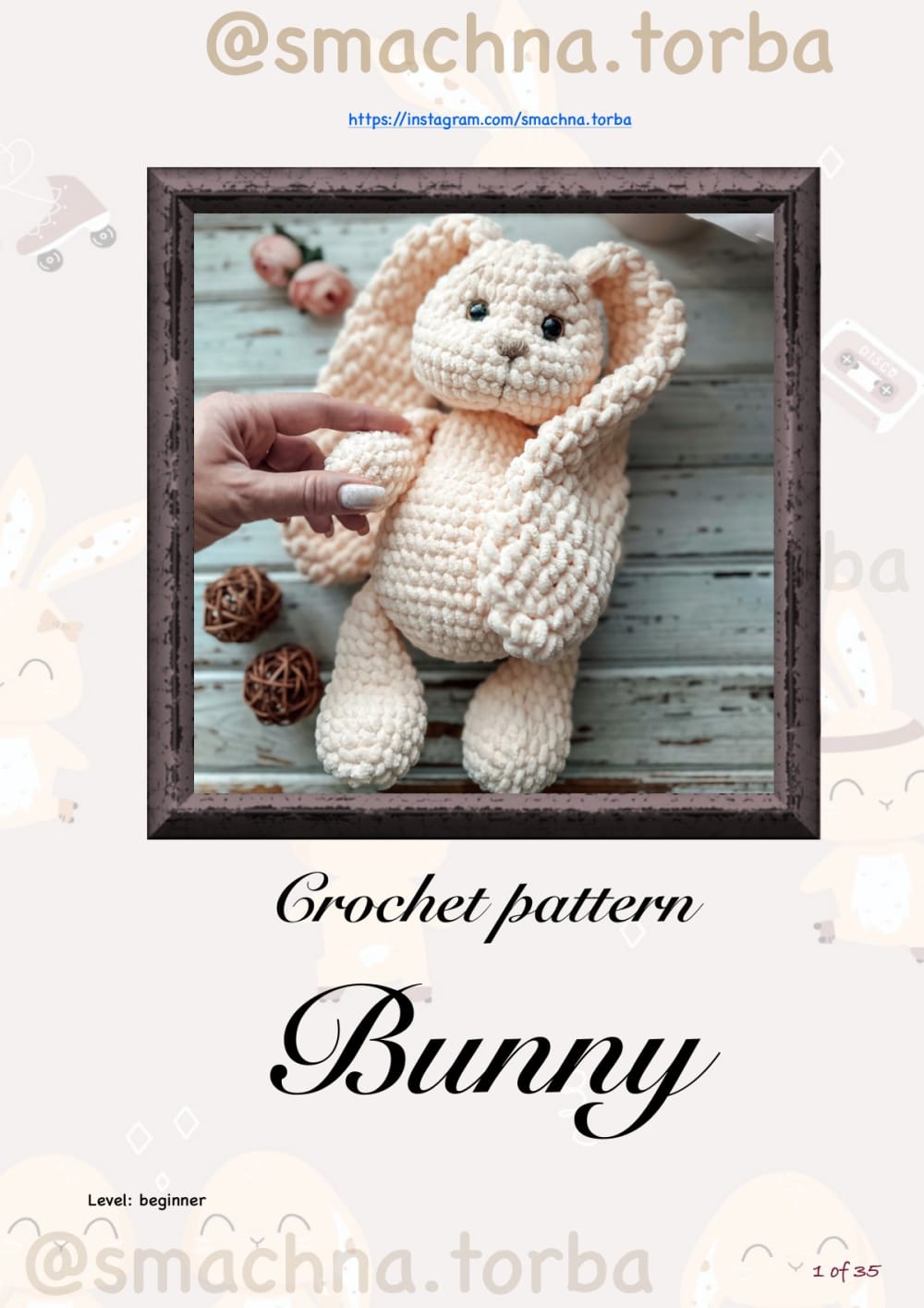 Peach plush crochet bunny with long floppy ears sitting in a wooden frame