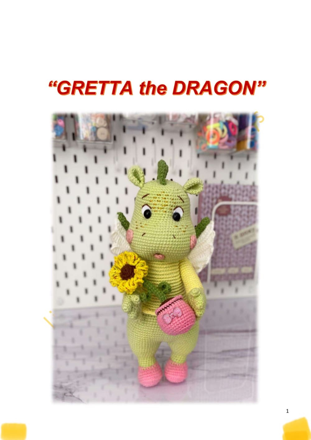 Green dragon amigurumi with cream wings, a yellow dress, pink shoes and a pink bag holding a sunflower