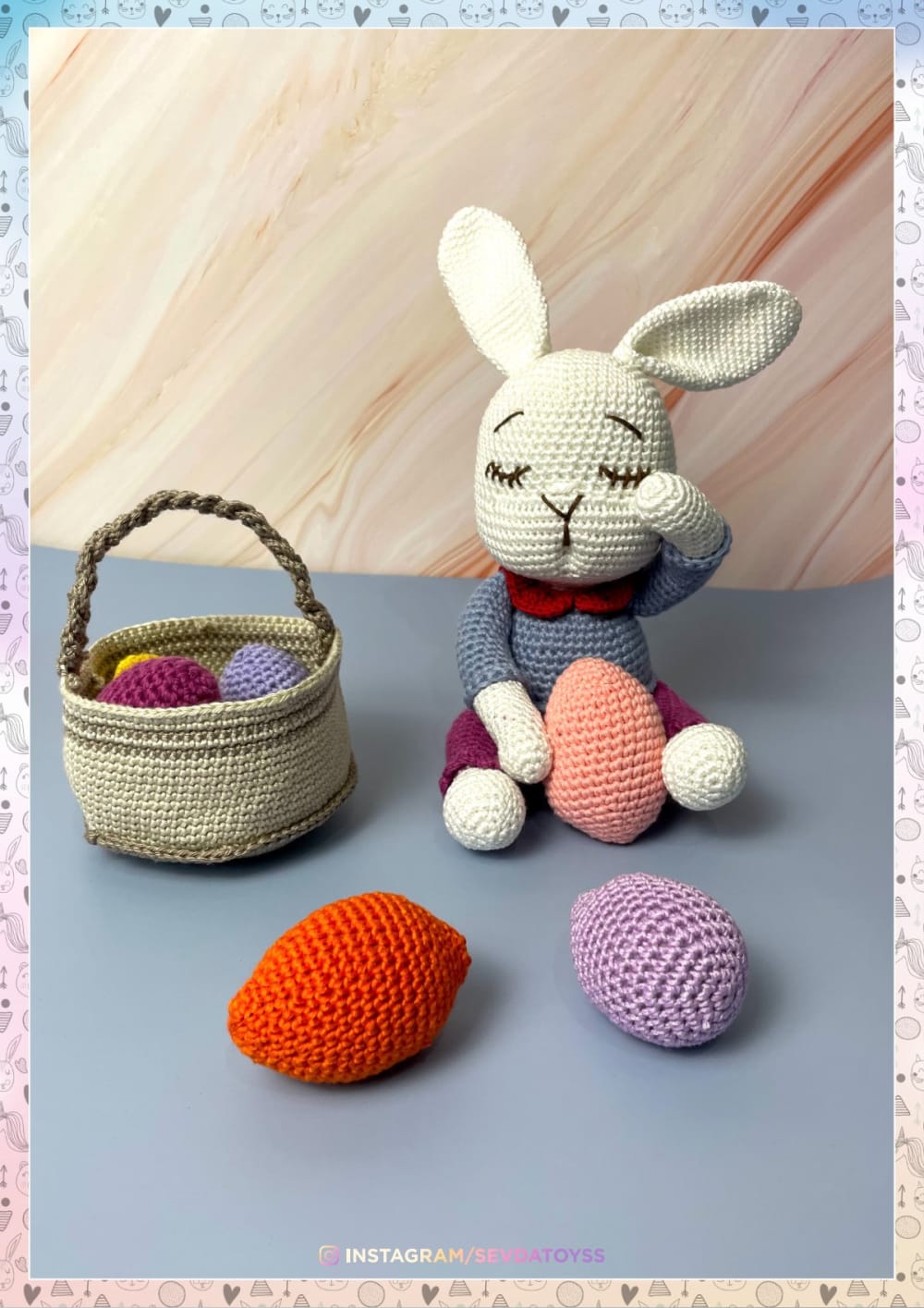 White crochet bunny with a red bow tie beside a basket and colorful crochet eggs