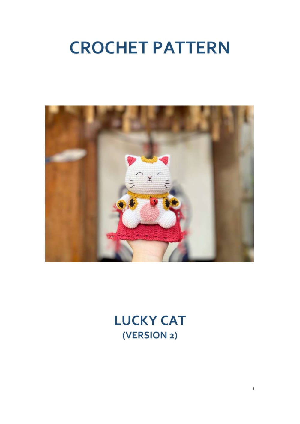 White lucky cat with an embroidered face and a red bib