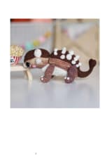 Two crochet ankylosaurus dinosaurs on a small wooden bench