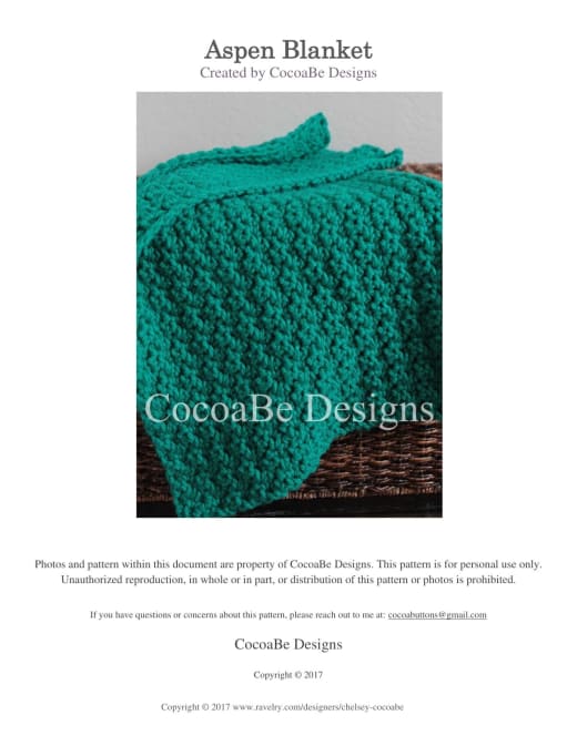 Thick emerald green chunky crochet Aspen baby blanket with a textured stitch and wavy edge on a wicker basket