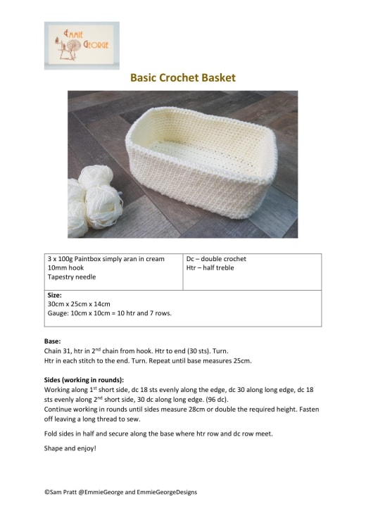 Cream rectangular crochet storage basket with balls of yarn beside it on a wooden floor