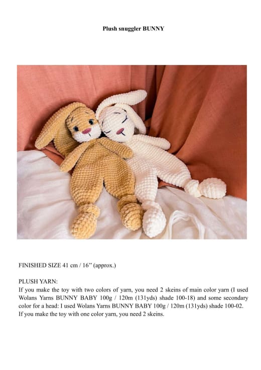 Two plush crochet bunny snugglers in mustard and cream lying on a rust-colored blanket