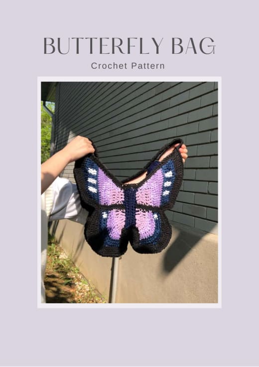Black, purple and lilac crochet butterfly bag held up against a wall