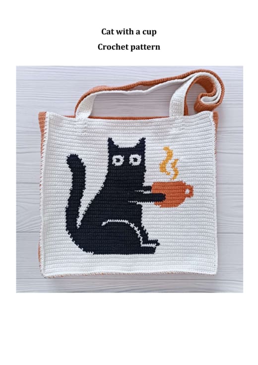 White crochet tote bag with a black cat holding a terracotta coffee cup and an orange strap