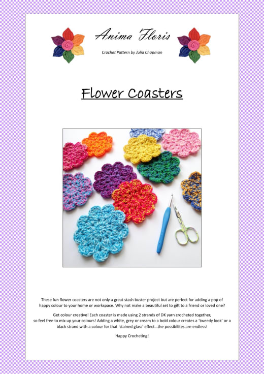Colorful crochet flower coasters in red, pink, yellow, blue, purple and green next to a blue crochet hook and scissors
