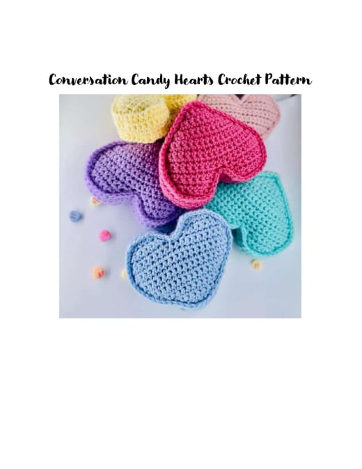 Pile of pastel crochet conversation hearts in yellow, pink, purple, blue and cream