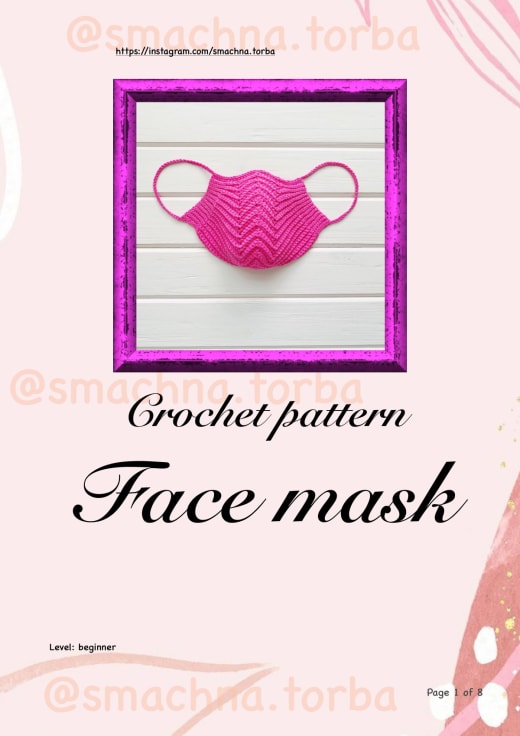 Bright pink crochet face mask with a zigzag ridge texture and chain ear loops on a frame