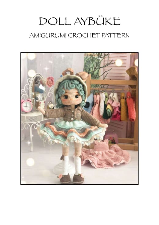 Amigurumi doll with curly mint green hair, a hat, a brown jacket and a layered ruffle skirt