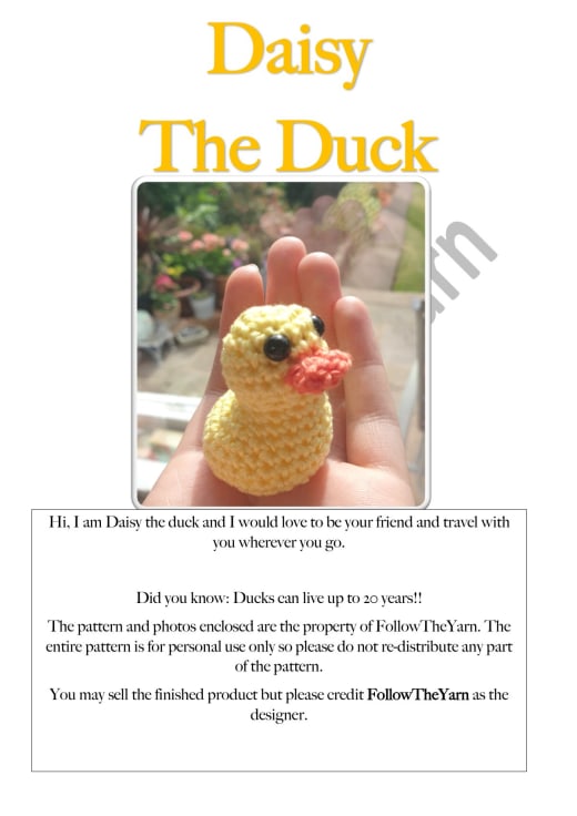 Tiny yellow crochet duck with an orange beak held in a hand