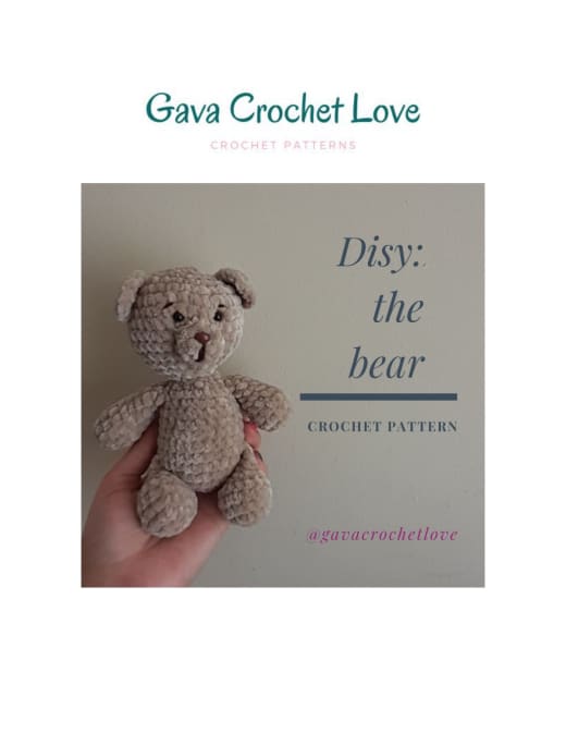 Taupe plush crochet teddy bear with a brown nose sitting in a hand