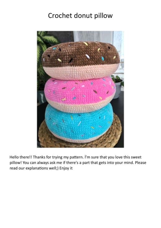 Stack of plush crochet donut pillows in peach, pink and blue