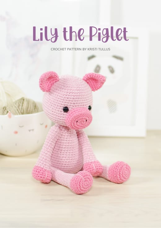 Pink crochet piglet sitting on a white table