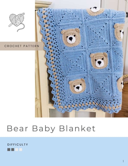 Blue baby blanket with beige teddy bear face squares and a white scalloped border
