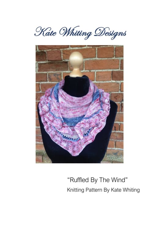 Pink and purple knitted crescent shawlette with a ruffled edge worn around the neck