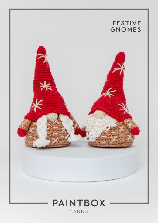 Two crochet Christmas gnomes with tall red hats and cream beards