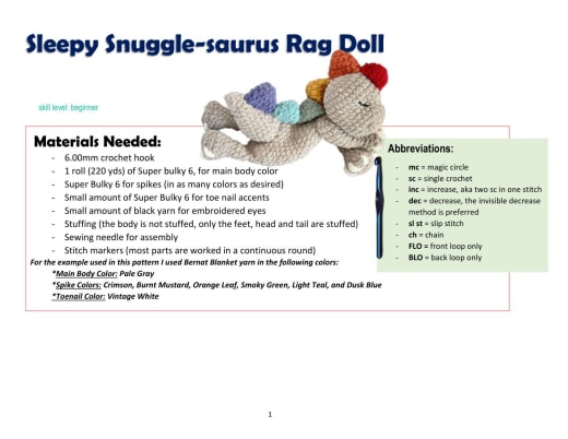 Grey snuggle-saurus dinosaur rag doll with rainbow spikes lying down