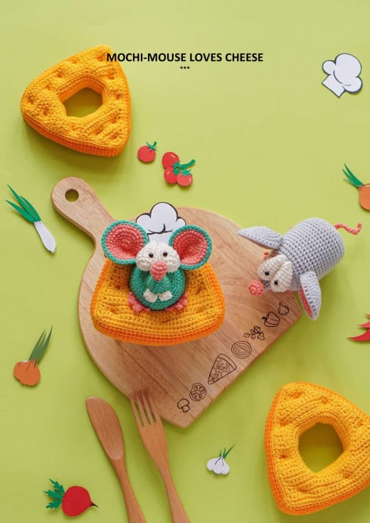 Small crochet mouse sitting on a slice of yellow cheese