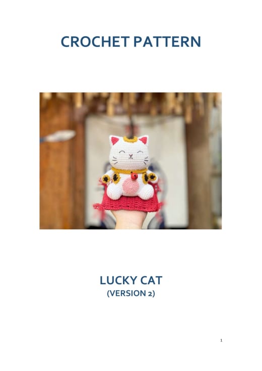 White lucky cat with an embroidered face and a red bib