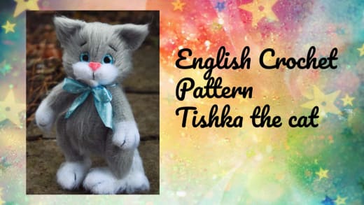 Tishka the gray crochet cat with a blue scarf