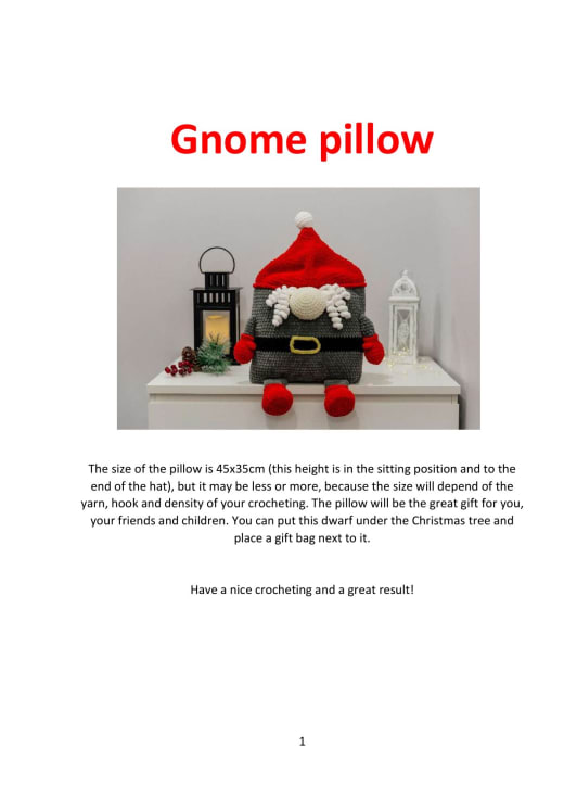 Plush crochet gnome pillow with a red hat and white beard by a Christmas display