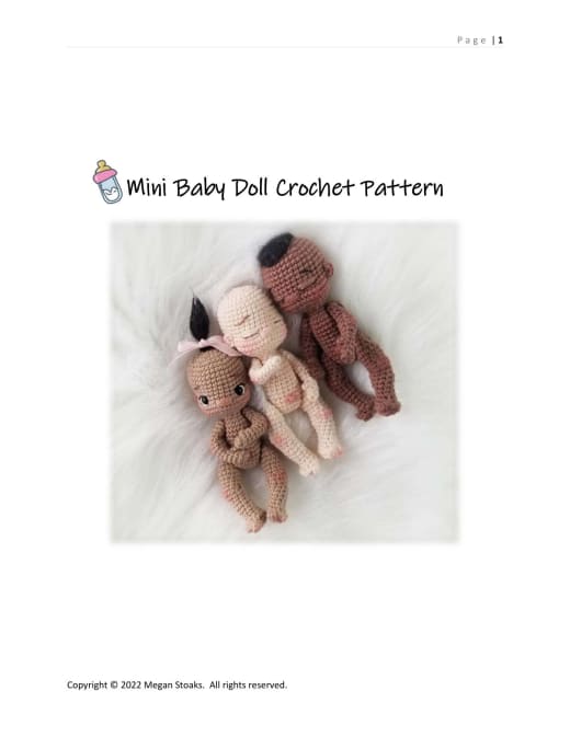 Two mini crochet baby dolls in different skin tones lying together