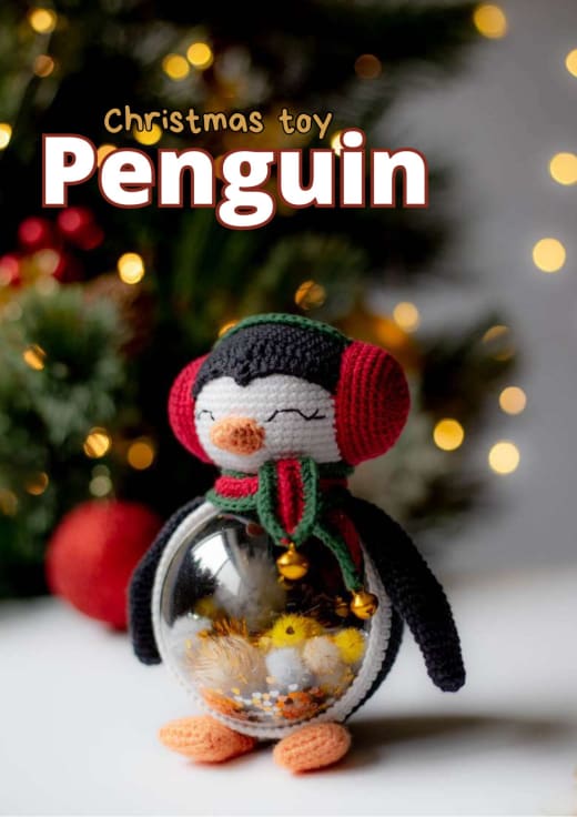 Crochet penguin with red earmuffs whose body is a clear ball filled with Christmas sequins