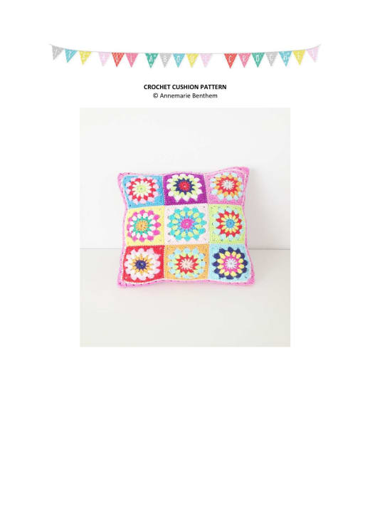 Crochet cushion with white-bordered granny squares in pink, red and purple