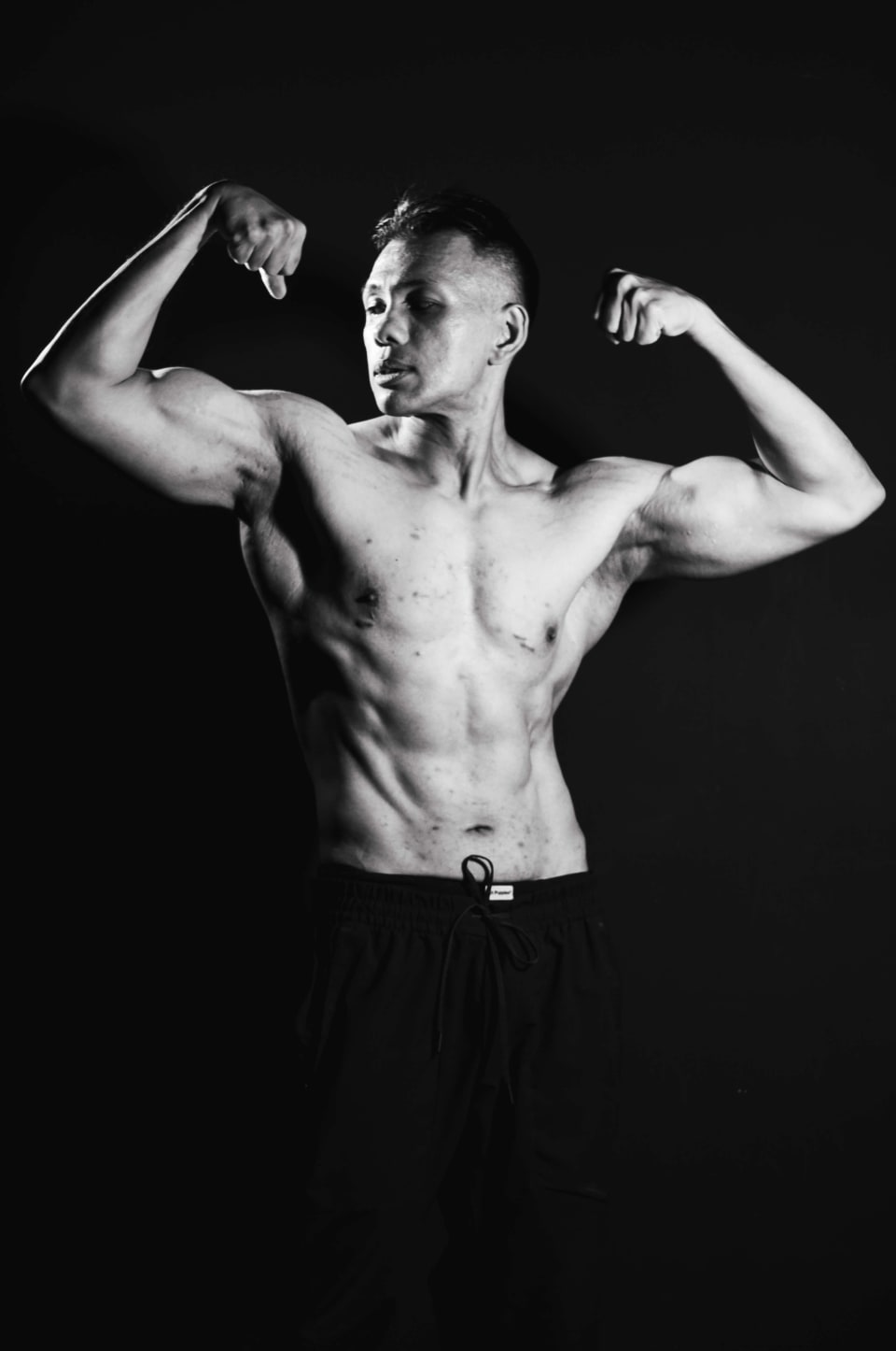 Front double-bicep pose, black and white studio