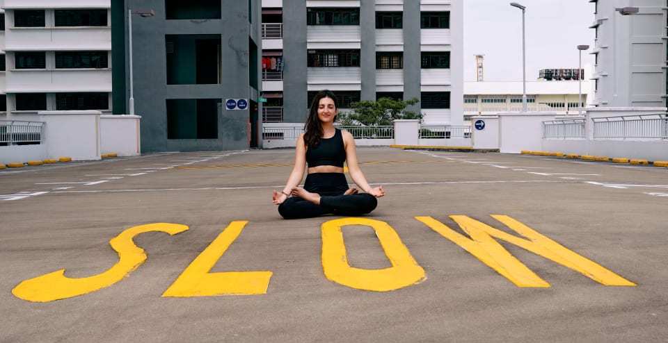 Seated meditation pose, 'SLOW' painted on the ground