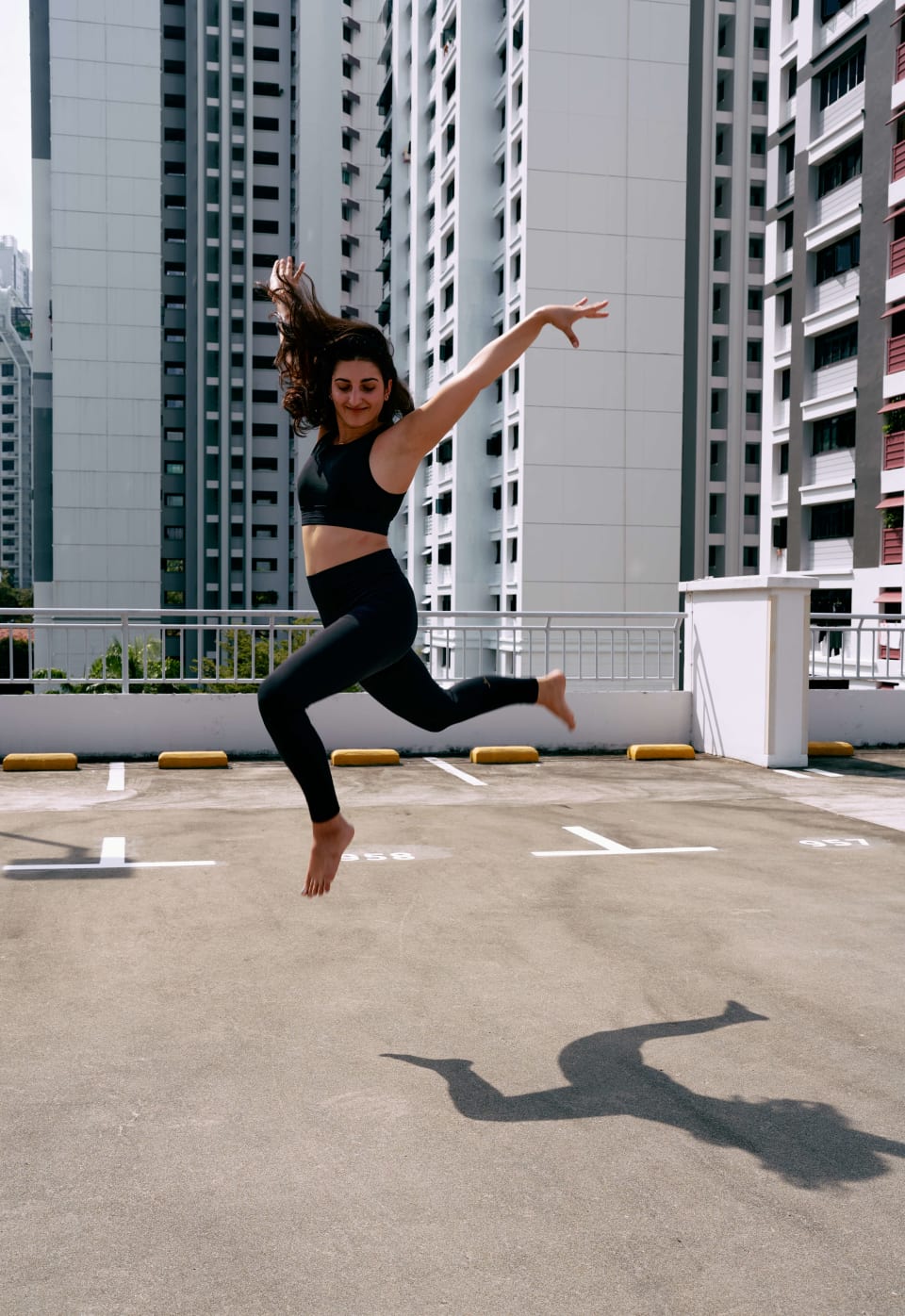 Mid-air jump, rooftop carpark, city skyline