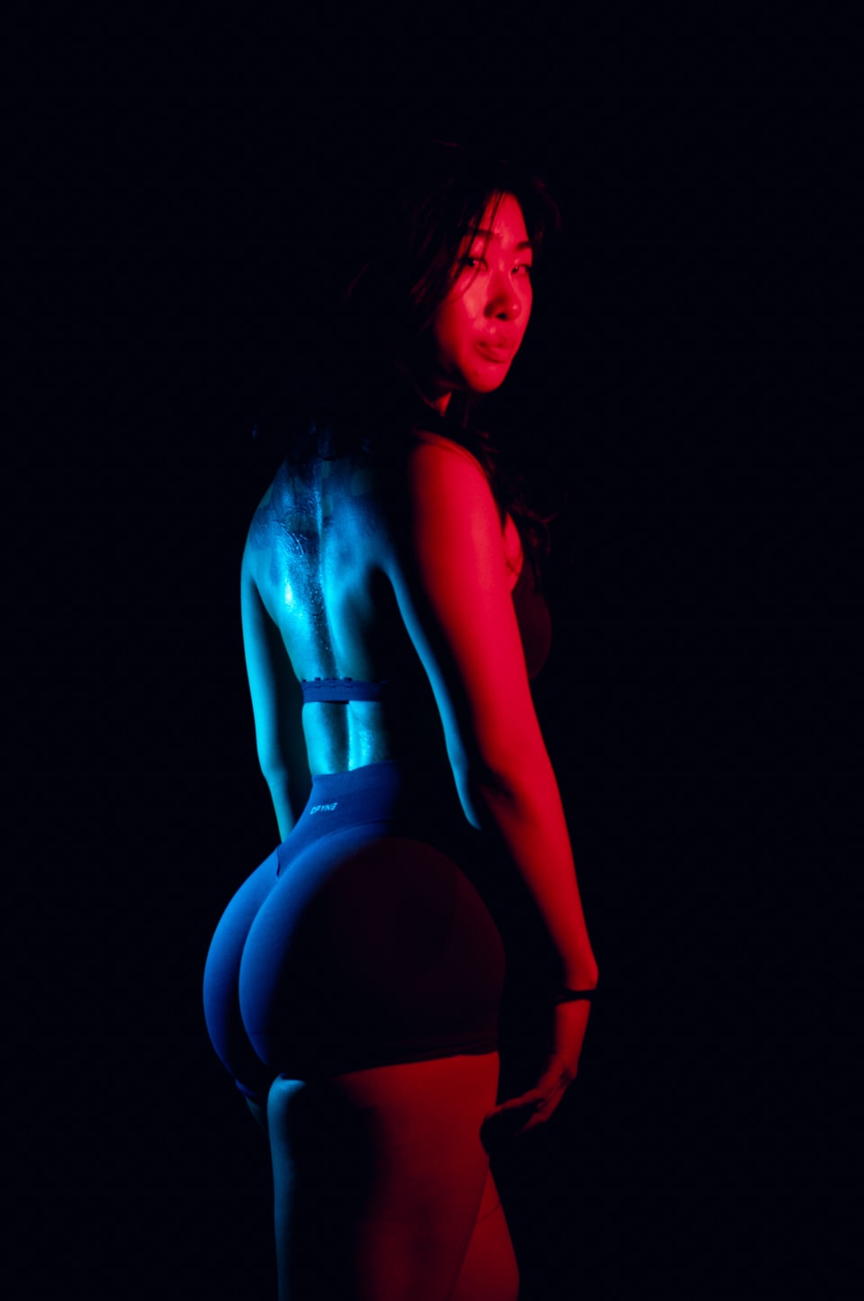 Silhouette portrait under split red and blue lighting