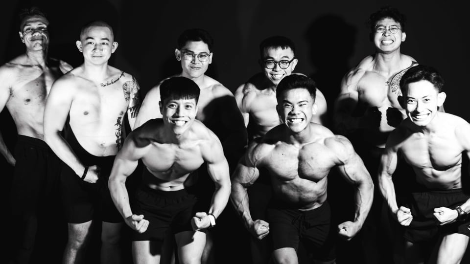 Group of gym members flexing together, black and white