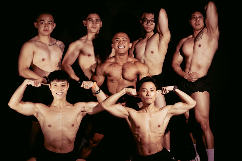 Group of gym members flexing together, black and white