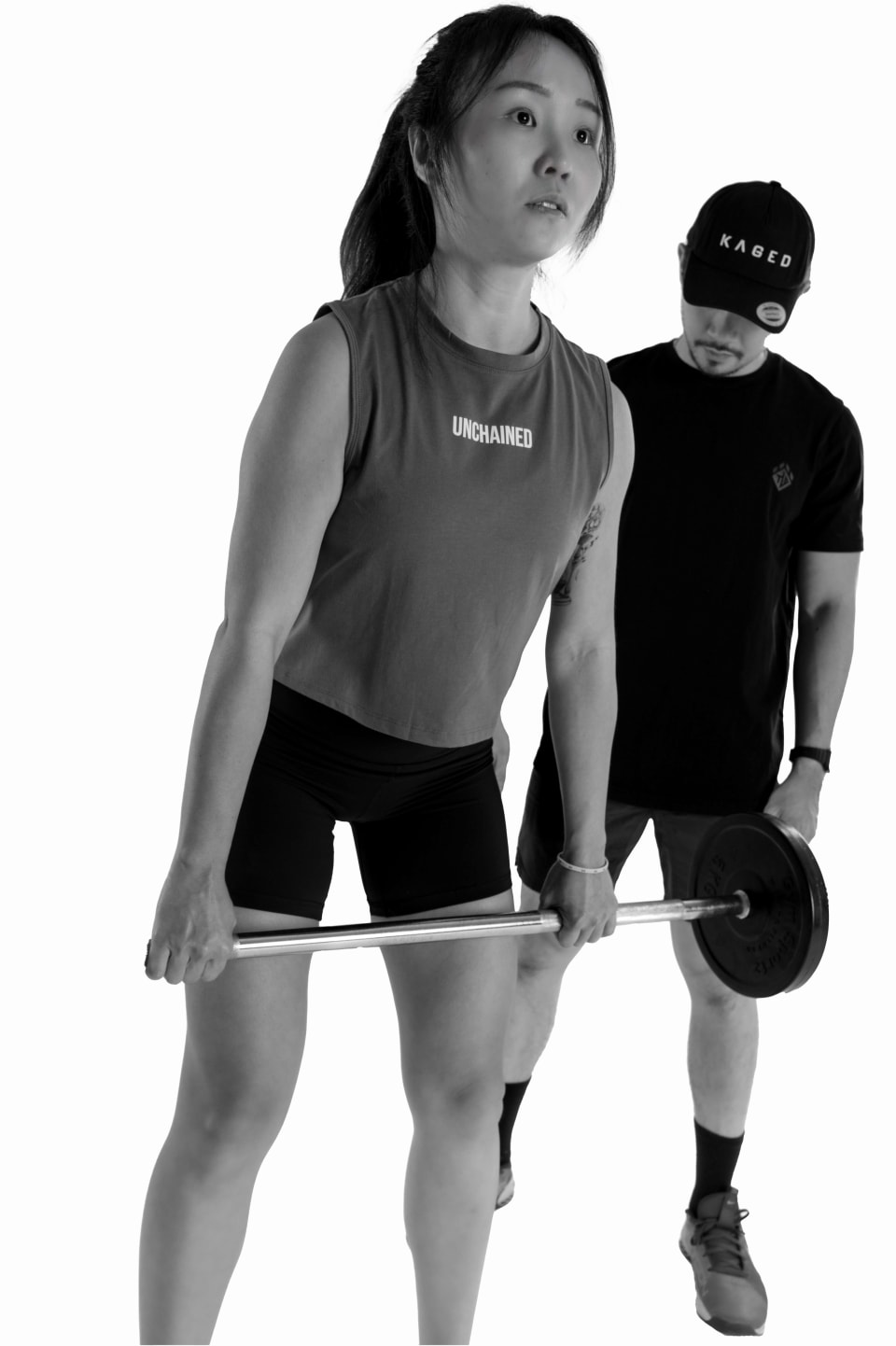 Training partners mid-lift with a barbell