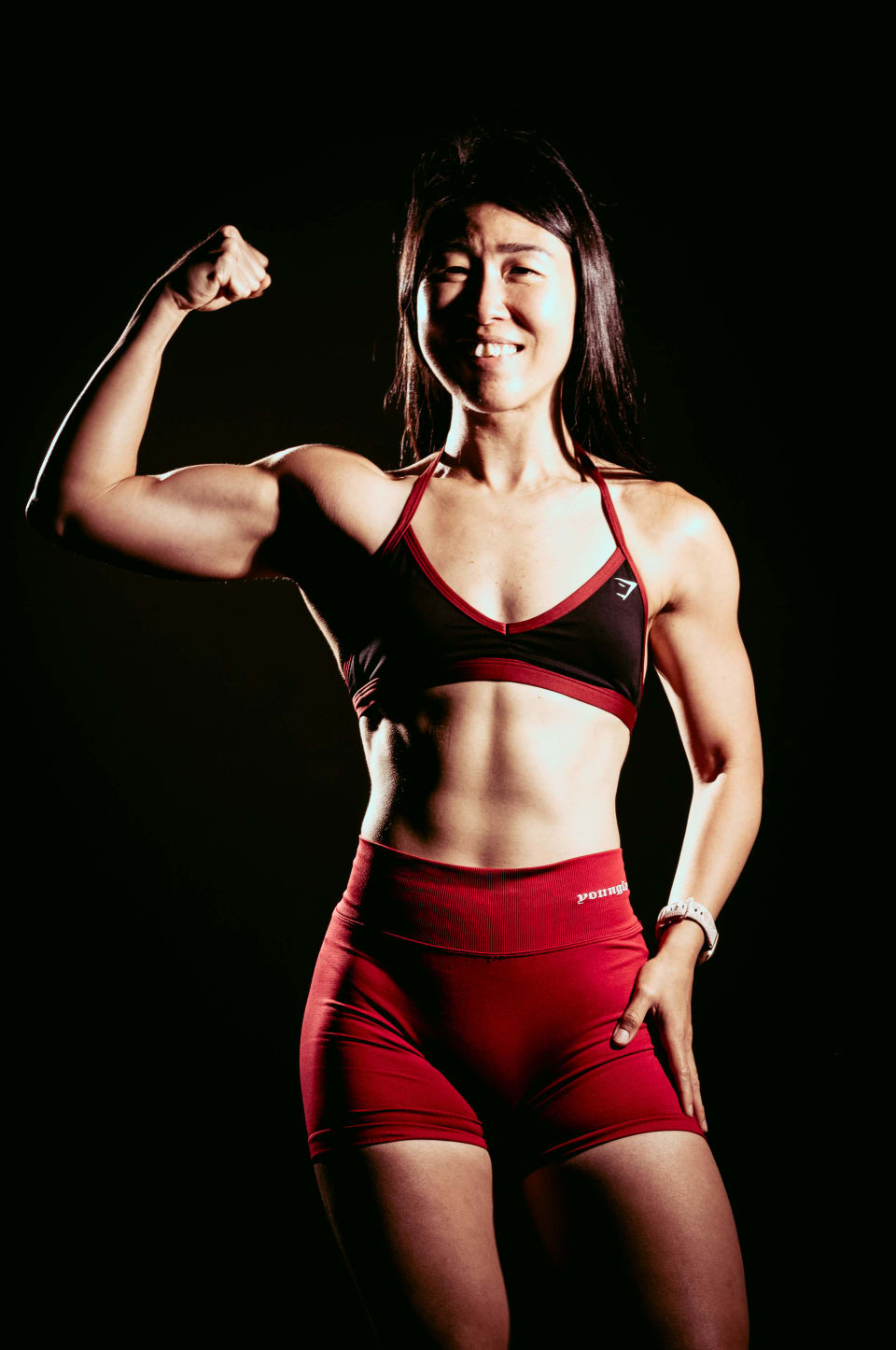 Standing portrait under warm light, smiling