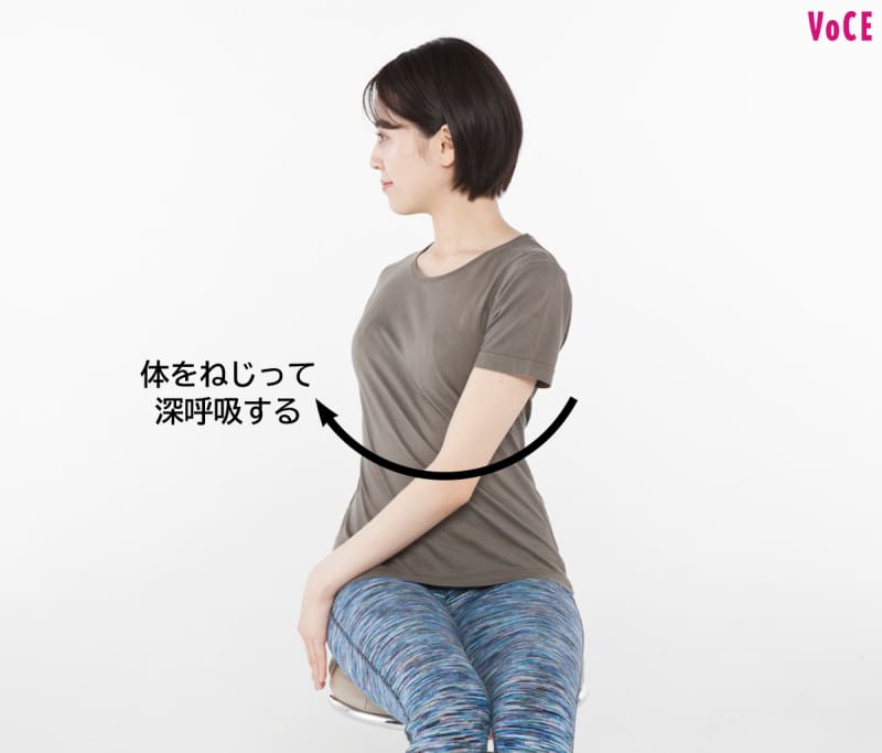 体をねじって深呼吸する