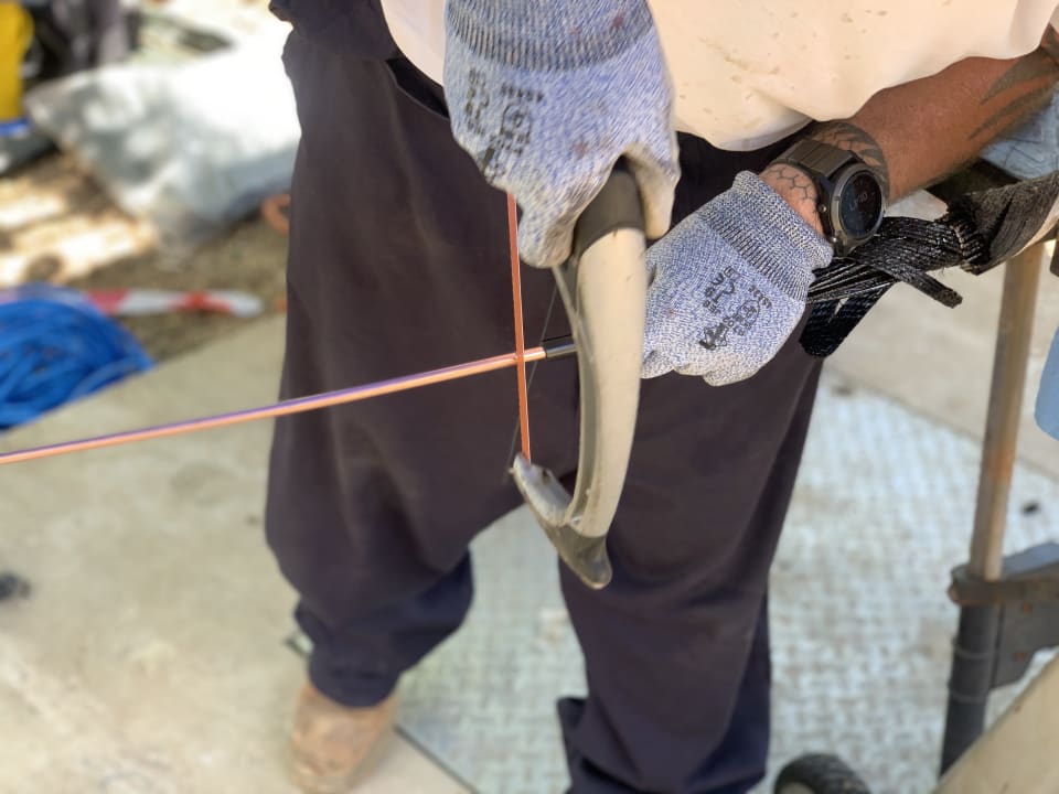 The Solomon Islands Domestic Network cable has its various layers stripped away in preparation for the “final splice” with the land cable, already installed in the beach manhole (under foot). The image shows the copper conductor in the core of the cable about to be removed. The outer layers of the cable can be seen to the right of the picture. (Credit: Vocus)