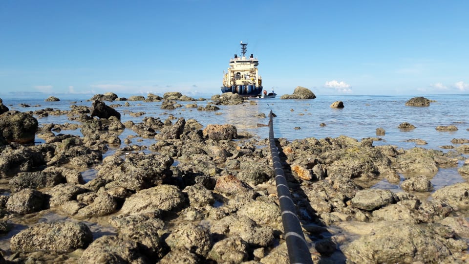 The Solomon Islands Domestic Network cable is floated ashore at Noro from the specialist cable-laying vessel the Ile de Brehat. The cable can be seen in the foreground (Credit: Simon Cluer, ASN)
