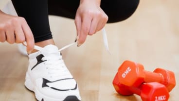 Diabète : semaine nationale de prévention juin 2024 : image d'une chaussure de sport en train d'être lacée à côté de deux poids au sol.